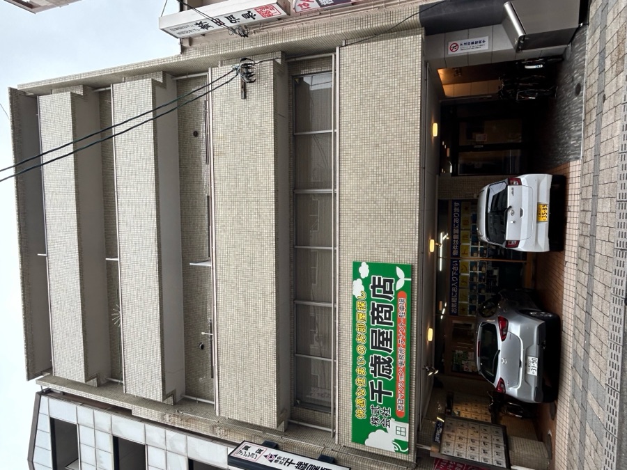 ビル外観。1階に千歳屋の緑の看板